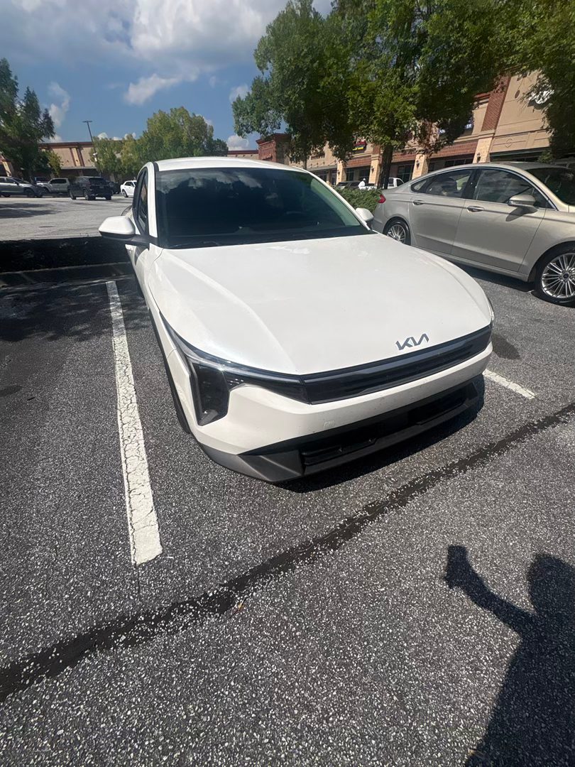 A white 2026 Kia K4 LXS from the Seven Fleet Group fleet, front three-quarter view