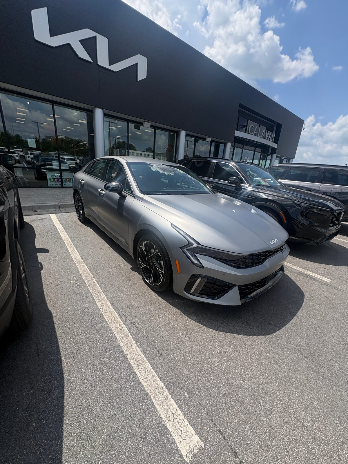 2026 Kia K5 GT-Line in matte grey, front three-quarter view
